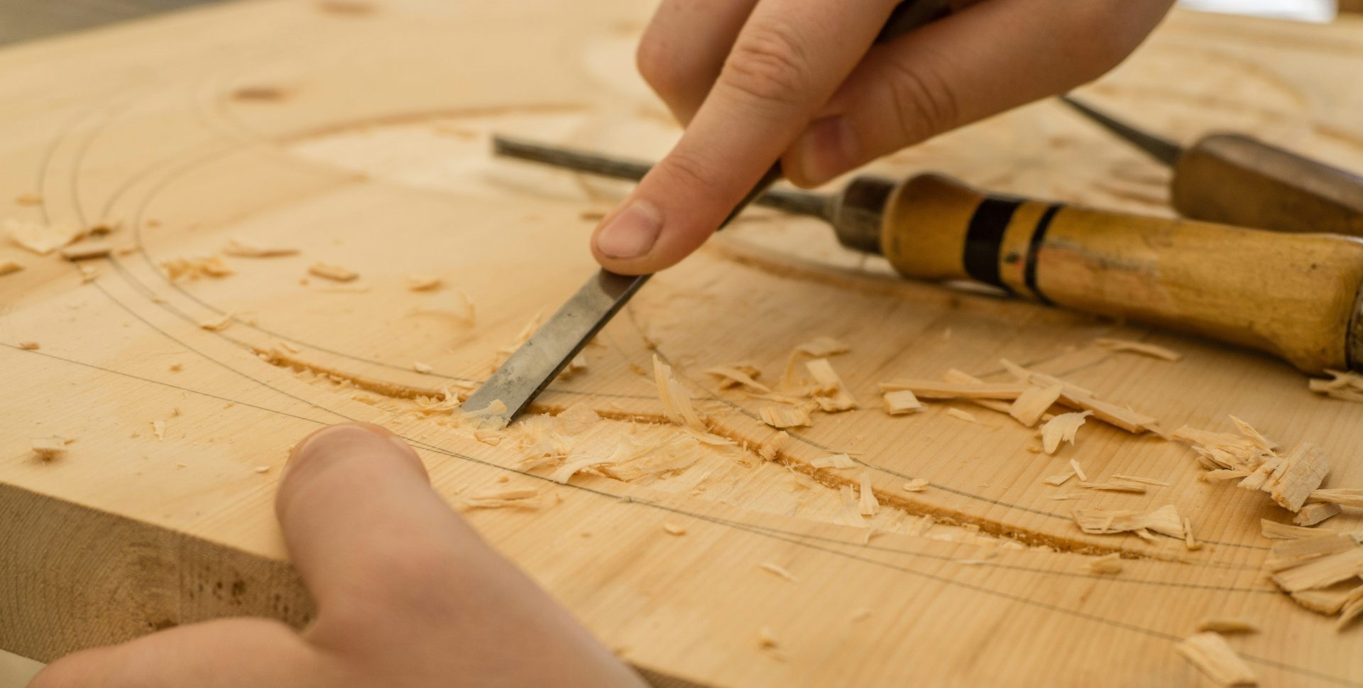 person in white shirt holding brown wooden table