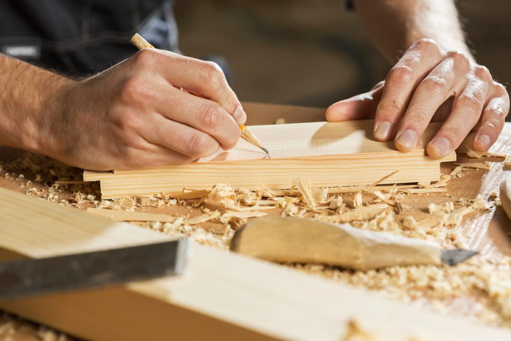 a person cutting a piece of wood